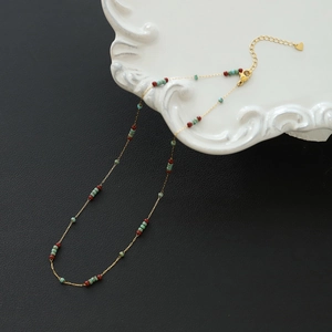 Macro shot of vintage colorful beads with heart pendant on fine gold chain