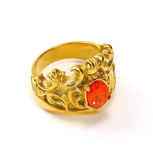 Detail of vintage crown ring with red gemstone inlay and golden floral embossing