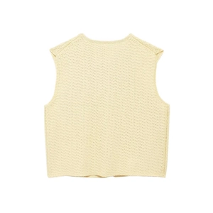 Detail of light yellow knit vest showing fine ribbed texture and premium craftsmanship