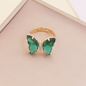 Detailed view of adjustable golden ring with green zircon butterfly and fine diamond inlay