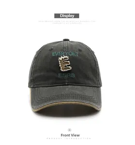 Detailed front view of charcoal grey baseball cap featuring letter embroidery and frayed edges