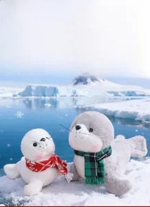 Vue détaillée des phoques en peluche de 18cm et 23cm avec écharpes dans la neige