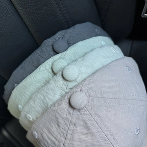 Detailed top view of cotton baseball caps showing stitching and embroidered eyelets