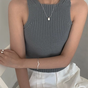 Minimalist silver wavy bangle and teardrop pendant necklace worn by a model