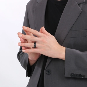 Black titanium steel ring with Roman numerals spinning design worn by male model