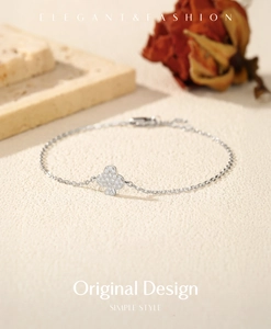 Detailed shot of S925 sterling silver clover bracelet with moissanite on textured surface