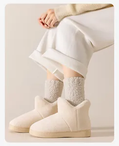 Détail de bottines d'intérieur en polaire corail blanc cassé et chaussettes épaisses