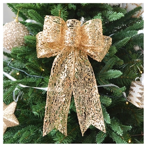 Close-up of champagne gold glitter mesh bow ornament on a decorated Christmas tree
