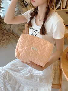Quilted heart pattern makeup bag in peach fabric with secure zipper and spacious interior