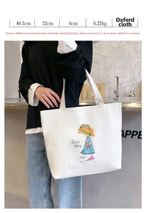 Detail view of large white canvas tote bag with girl and cat print and size dimensions