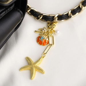 Gold starfish seashell and coconut tree keychain with white pearls on black strap