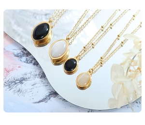 Detail of vintage cat eye stone pendant necklaces displayed on a reflective mirror surface