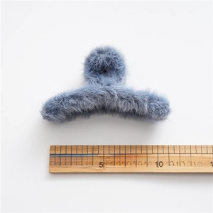 Detail van de 12 cm grote pluche haarklem in grijsblauw met liniaal voor afmeting