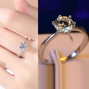Elegant six-prong silver ring with a sparkling round moissanite stone shown on finger