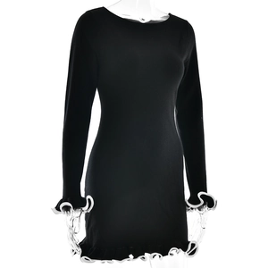 Detail of contrast white wavy hem and cuffs on a black slim-fit knit mini dress