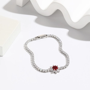 Elegant silver tennis bracelet featuring emerald-cut red stone and petal-shaped zirconias