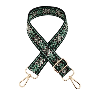 Close-up of ethnic geometric embroidered strap with adjustable light gold metal hardware
