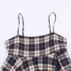 Plaid sleeveless top with blue and brown check pattern on a clean white background