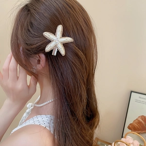 Détail de la pince à cheveux étoile de mer en raphia avec cristal sur les cheveux