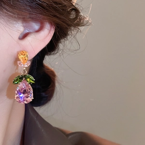 Close-up of teardrop zircon earrings with orange and pink crystals on model's ear