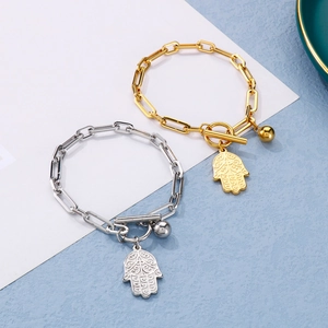 Detail of gold and silver stainless steel paperclip bracelets with Hamsa palm and OT toggle