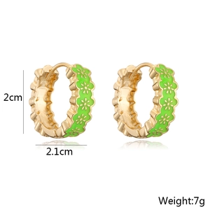 Detail view of 18k gold plated hoop earrings featuring colorful green floral enamel inlay