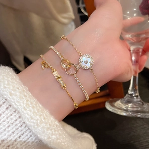 Detailed close-up of gold-plated bamboo bracelets and clover charm set on wrist