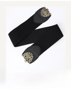 Detail of vintage hollow gold metal buckle on a black wide elastic belt for women