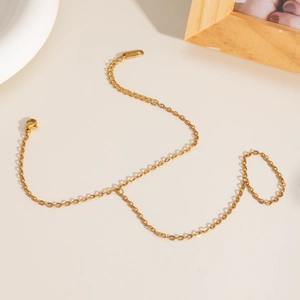 Bracelet bague élégant en acier inoxydable doré avec perles sur un bureau beige chaleureux