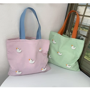 Detail of striped canvas tote bags with 3D duck decorations and colorful handles