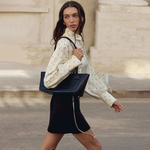 Chemise chic blanche à pois à manches longues avec élégant sac à main noir texture crocodile