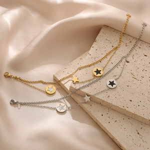 Double-layered star charms bracelet in gold and silver finish on silk and stone backdrop