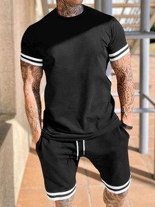 Detail of men's black sports set showing white contrast stripes on sleeves and shorts hem