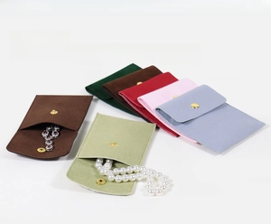 Vue macro de pochettes à bijoux colorées en microfibre avec boutons et collier de perles
