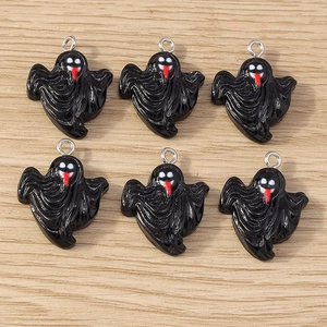 Macro shot of six black ghost charms with metal loops on a textured wooden surface