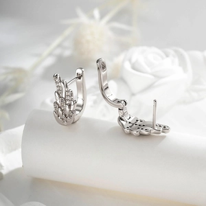 Silver angel wing hoop earrings with sparkling cubic zirconia on a floral background