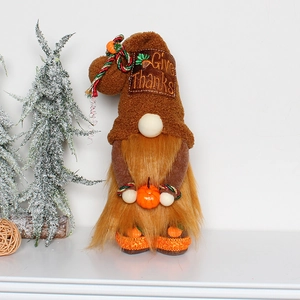 Detail of autumn gnome plush holding a pumpkin with Give Thanks embroidery