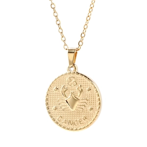 Detailed view of a golden circular Cancer zodiac pendant with crab engraving and lettering