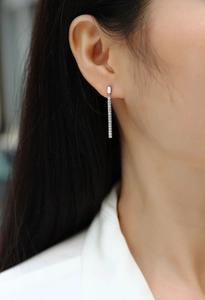 Detailed close-up of 925 sterling silver drop earrings with pavé set moissanite stones