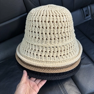 Detail view of hollow knit bucket hats in beige, brown and black with wavy texture