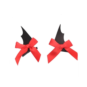 Detail of Halloween bat wing hair clips with red bows on a clean white background