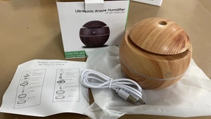 Unboxing detail of a 300ml wood grain ultrasonic humidifier with USB cable and manual