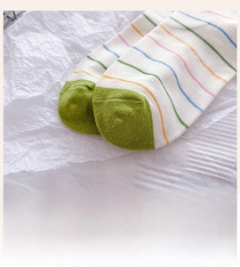 Detail of reinforced green contrast toe and colorful striped cotton crew socks
