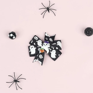 Detail of Halloween bow clip with ghost print, Boo text, and pumpkin basket decoration