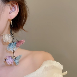 Detailed view of floral tassel earrings with fabric petals and elegant long fringe drape