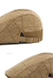 Detail of wool blend plaid flat cap showing the adjustable metal buckle and curved brim