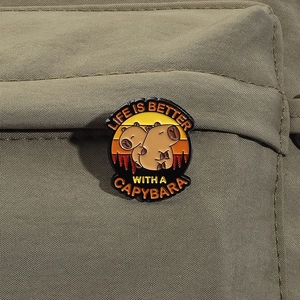 Detail of Capybara enamel pin on green canvas bag with 'Life is Better' text