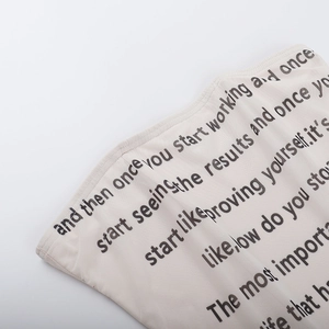 Detailansicht von schwarzer Kunst-Typografie auf dem elfenbeinfarbenen Strick-Schlauchtop