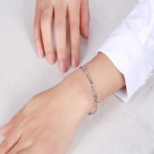Classic S925 sterling silver Figaro chain bracelet worn on wrist with marble background