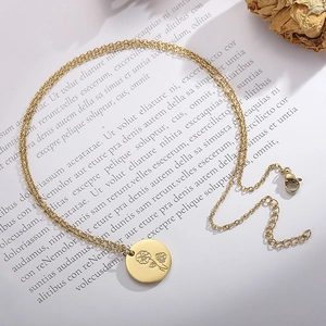 Collier en acier inoxydable doré avec pendentif fleur de naissance gravé sur fond papier
